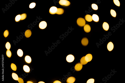 black background with golden glittering lights bokeh. abstract defocused pattern