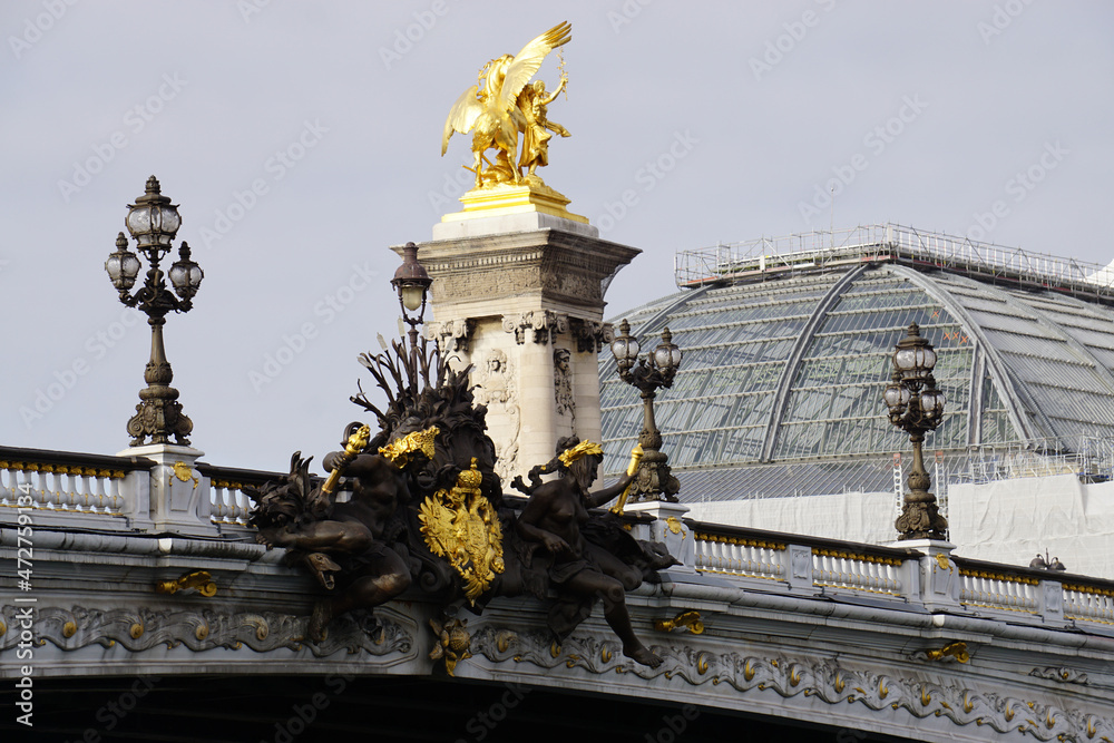 Fototapeta premium view of pont alexandre iii with carved sculptures alongside, lamp post and glass building downtown paris france
