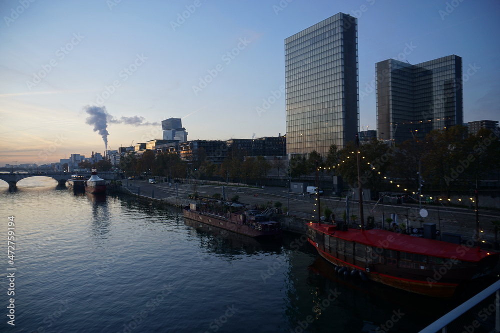downtown skyline at sunrise with barges on seine river, old stone bridge and highway  paris france