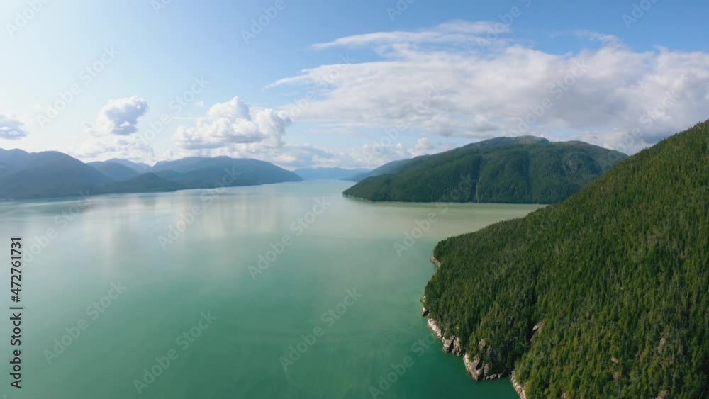 Aerial top shot flying over amazing sea with sun glare and high mountains at summer sunset amazing view. Shooting from helicopter beautiful nature landscape. Aerial top shot flying over amazing sea with sun glare and high mountains at summer sunset amazing view. Shooting from helicopter beautiful nature landscape.