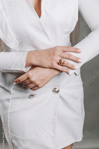 a girl in a white jacket. close-up of a hand with a ring