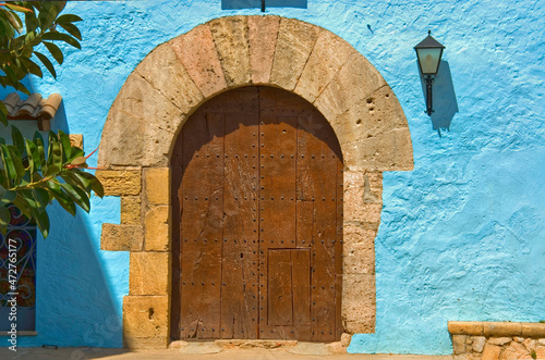 Puerta de madera en casa antigua con fachada azul photo