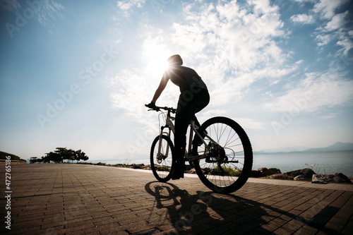 Fototapeta Naklejka Na Ścianę i Meble -  Riding bike on the sunrise coast path