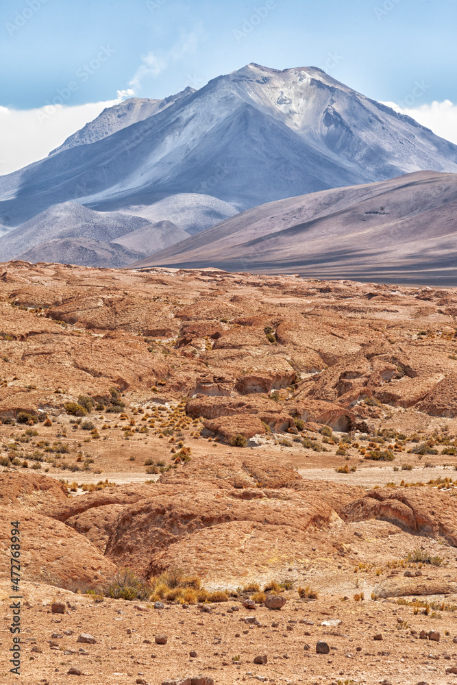 Bolivia, Atacama Desert. An active volcano rises above an old lava field.