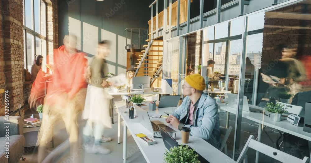 Zoom-out time lapse of motivated employees working and relaxing in modern open space office on sunny day. Career and workspace concept.