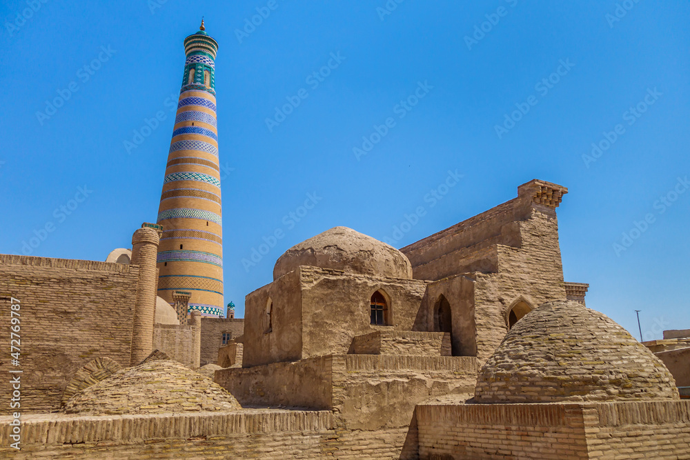 Panorama of ancient mausoleums in historical part of Khiva, Uzbekistan. Colorful minaret of Islam Khoja, one of symbols of city, in background