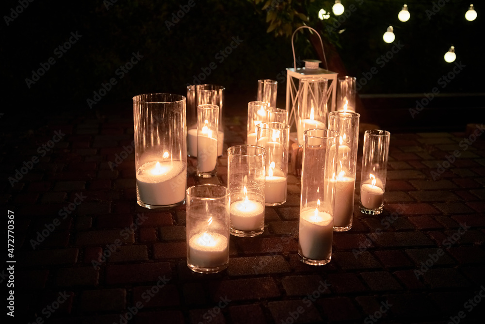 Night wedding ceremony decorations with candles in glass vases and bulb  lights on tree outdoors, copy space Photos | Adobe Stock