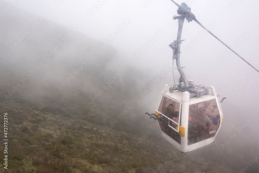 Fototapeta premium Ecuador, Quito. TeleferiQo cable car in clouds. Rises to 13,000 ft, one of highest in world. Bikers have option to ride back down