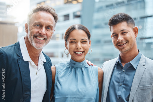 Portrait of a group of businesspeople standing together against a city background
