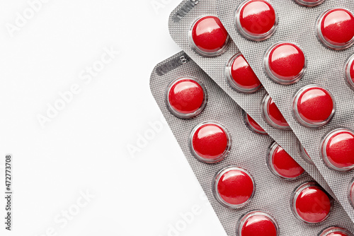 Red pills in a package, close-up. Pharmacy. Medicines. Studio shot, copy space, white background.