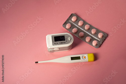 Wallpaper Mural Pulse oximeter for measuring level of oxygen in blood, thermometer, tablets in blister,  on a pink background. Health device without people. Torontodigital.ca