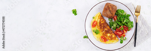 Omelette with tomatoes, ham, cheese and corn salad on plate. Frittata - italian omelet. Top view, banner