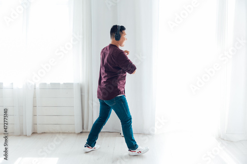 Asian man dancing to music alone at home