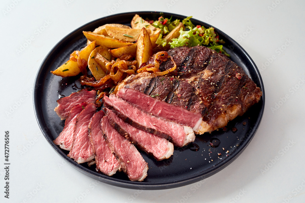 Tasty grilled steak and rustic potatoes on plate Tasty grilled steak and rustic potatoes on plate