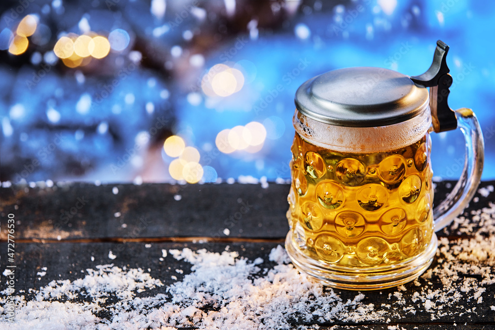 Glass of beer on table with snow Glass of beer on table with snow