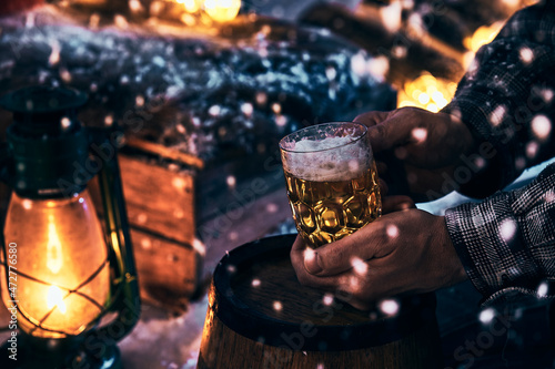 Man with glass of beer at winter night