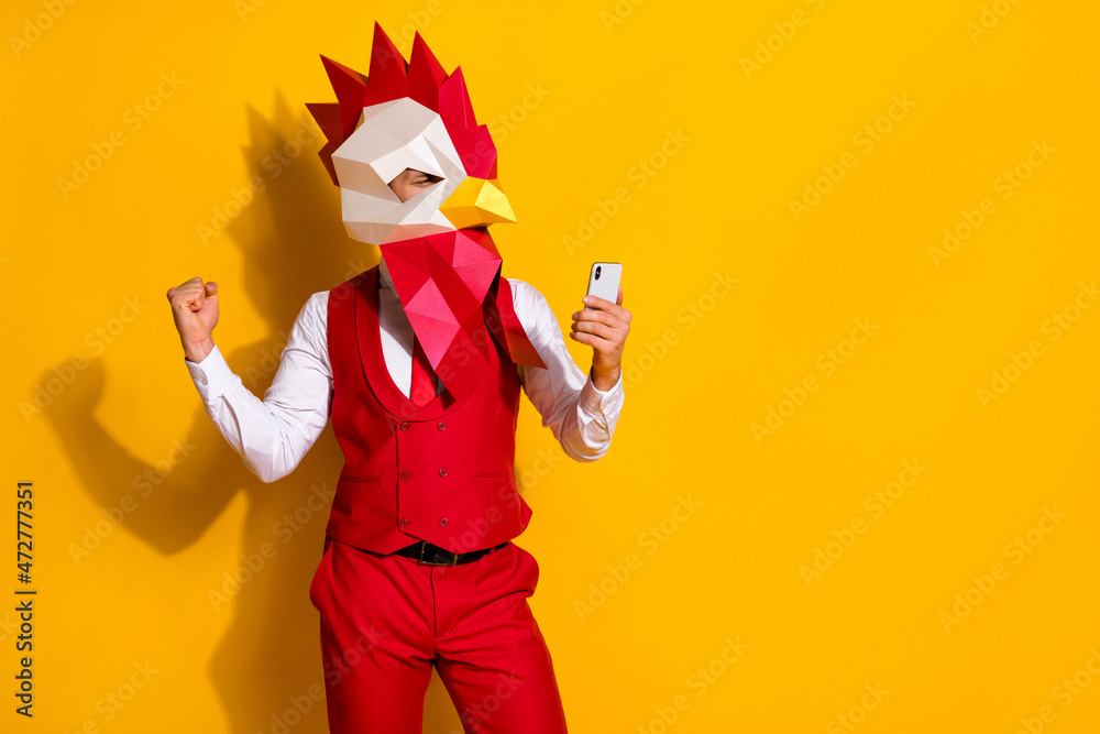 Photo of influencer guy hold telephone rejoice hundred likes wear cock mask red suit isolated yellow color background - obrazy, fototapety, plakaty 