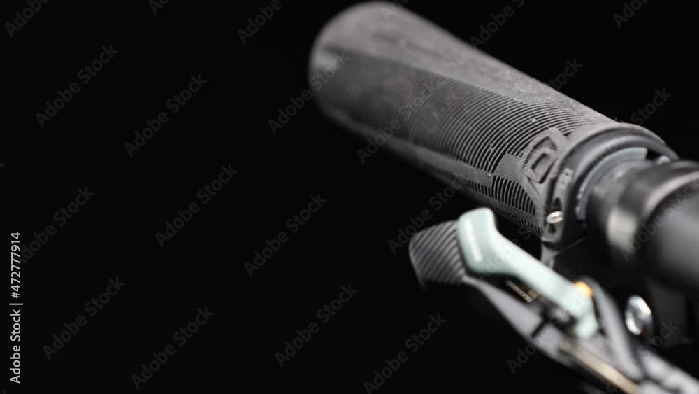 Close up on mountain bike handlebar on black background.