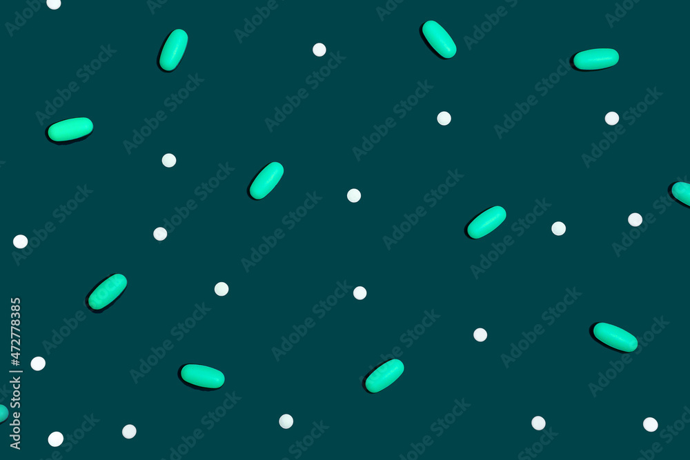 Blue background with many drugs in capsules and tablets of different colors scattered on the surface Blue background with many drugs in capsules and tablets of different colors scattered on the surface