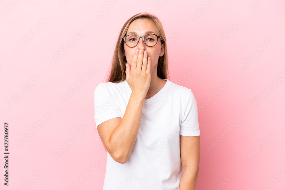 Young English woman isolated on pink background covering mouth with hand Young English woman isolated on pink background covering mouth with hand