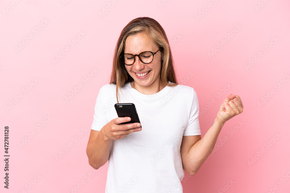 Young English woman isolated on pink background surprised and sending a message Young English woman isolated on pink background surprised and sending a message