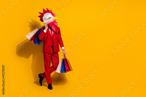 Photo of confident cocky client hold outfit packages wear chicken mask red tux isolated yellow color background