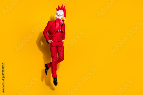 Photo of wacky freak guy jump hands pockets wear cock polygonal mask red tux isolated yellow color background