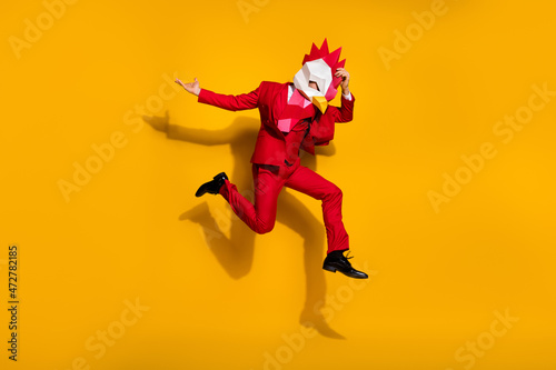 Photo of carefree model guy absurd jump wear cock polygonal mask red tux shoes isolated yellow color background