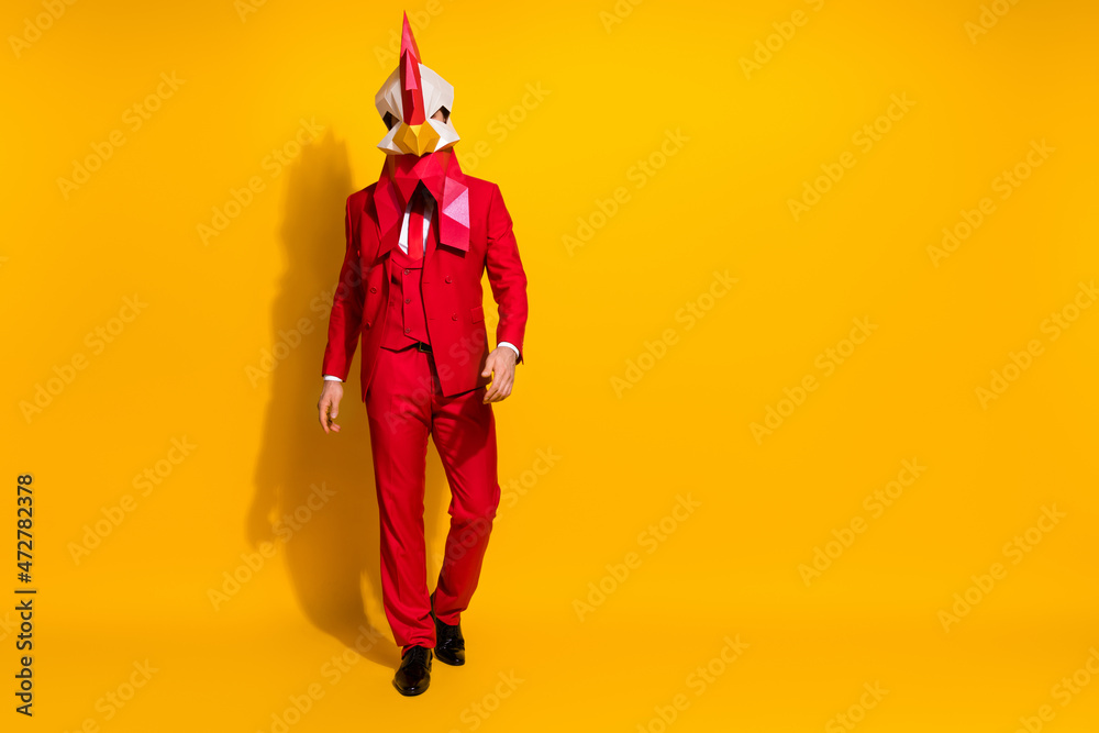 Photo of confident executive ceo festive walk wear chicken polygonal mask red tux isolated yellow color background Photo of confident executive ceo festive walk wear chicken polygonal mask red tux isolated yellow color background