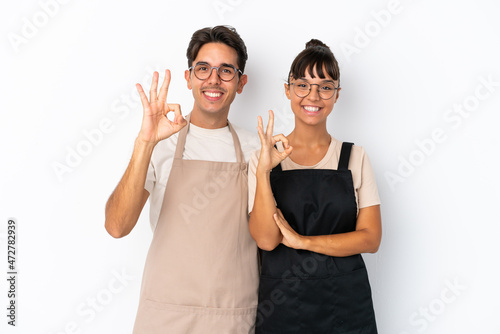 Restaurant mixed race waiters isolated on white background showing an ok sign with fingers