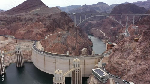 Orbiting aerial view of the Hoover Dam with the Mike O'Callaghan–Pat Tillman Memorial Bridge in sight. 