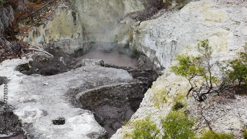 Pan shot of boiling crater in hydrothermal area of Wai-o-tapu during daytime photo