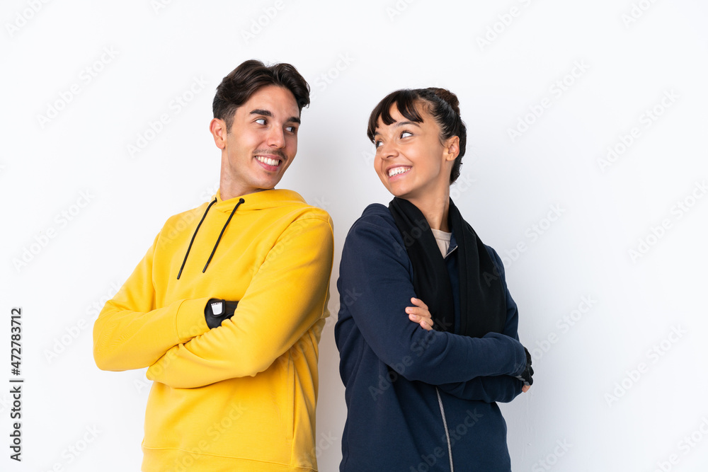Young mixed race sport couple isolated on white background looking over the shoulder with a smile Young mixed race sport couple isolated on white background looking over the shoulder with a smile