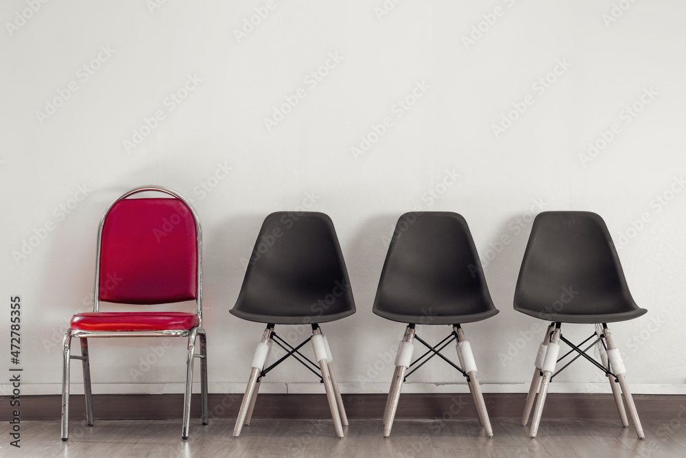 Obraz premium Selected red chairs in rows of chairs on wooden floor against white wall background. Vintage style. concept for business in job interview. Selection and job vacancies. with copy space