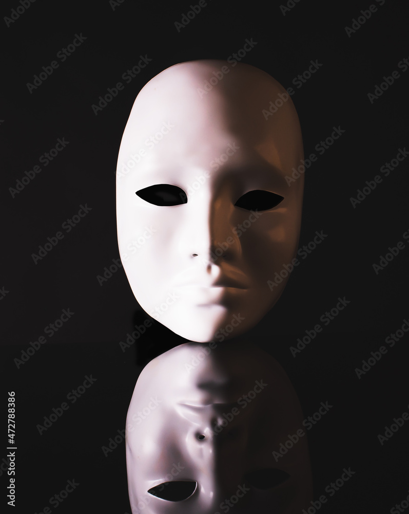 Black and white, conceptual image. White mask, face with reflection on a black background. - obrazy, fototapety, plakaty 