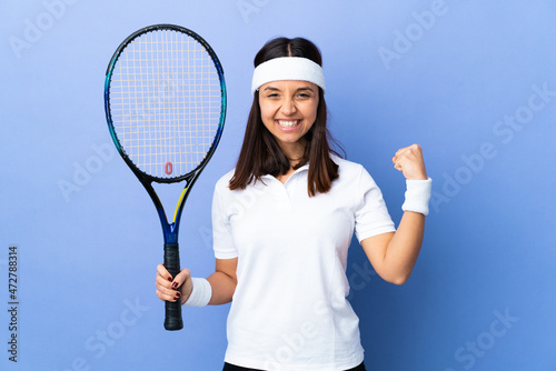 Young woman tennis player over isolated background doing strong gesture