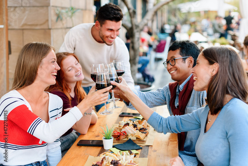 Happy group of young friends celebrating at a restaurant