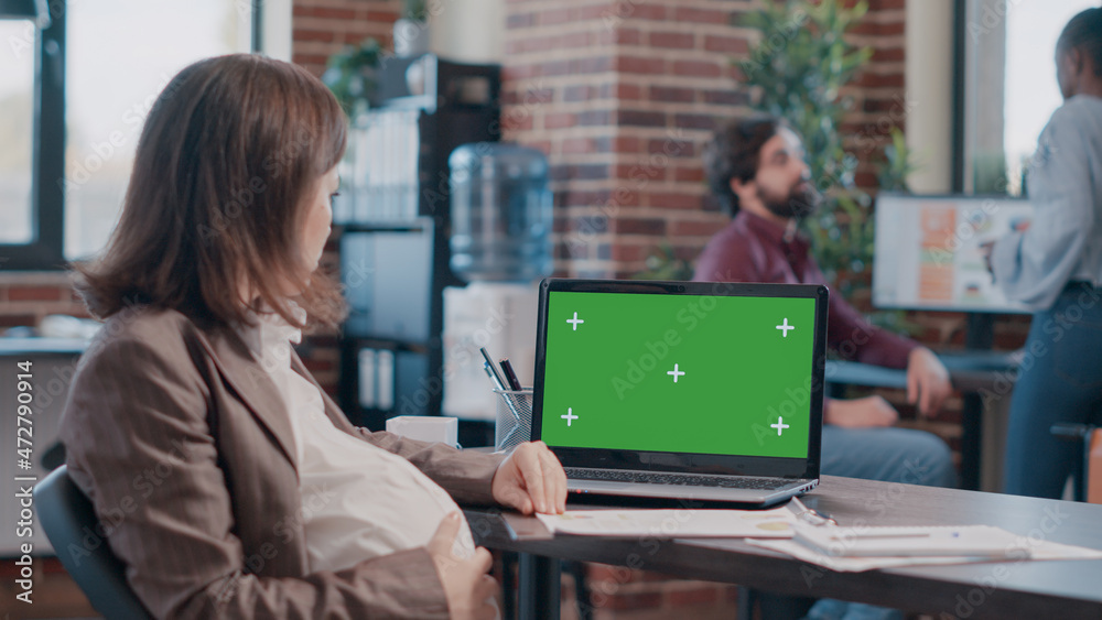 Adult expecting baby and working with green screen on laptop to design project. Pregnant business woman having isolated mockup template and background with chroma key on display. Adult expecting baby and working with green screen on laptop to design project. Pregnant business woman having isolated mockup template and background with chroma key on display.