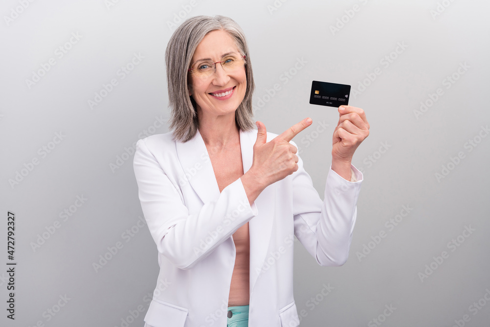 Photo of friendly white hairdo elder hr lady index card wear eyewear jacket isolated on grey color background Photo of friendly white hairdo elder hr lady index card wear eyewear jacket isolated on grey color background