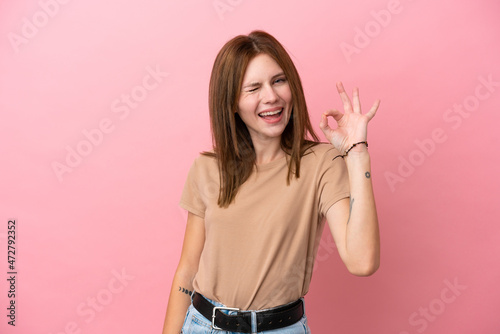 Young English woman isolated on pink background showing ok sign with fingers