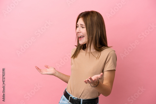 Young English woman isolated on pink background with surprise expression while looking side