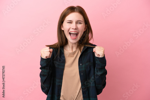 Young English woman isolated on pink background celebrating a victory in winner position