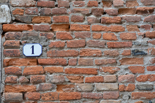 old brick wall with house number one