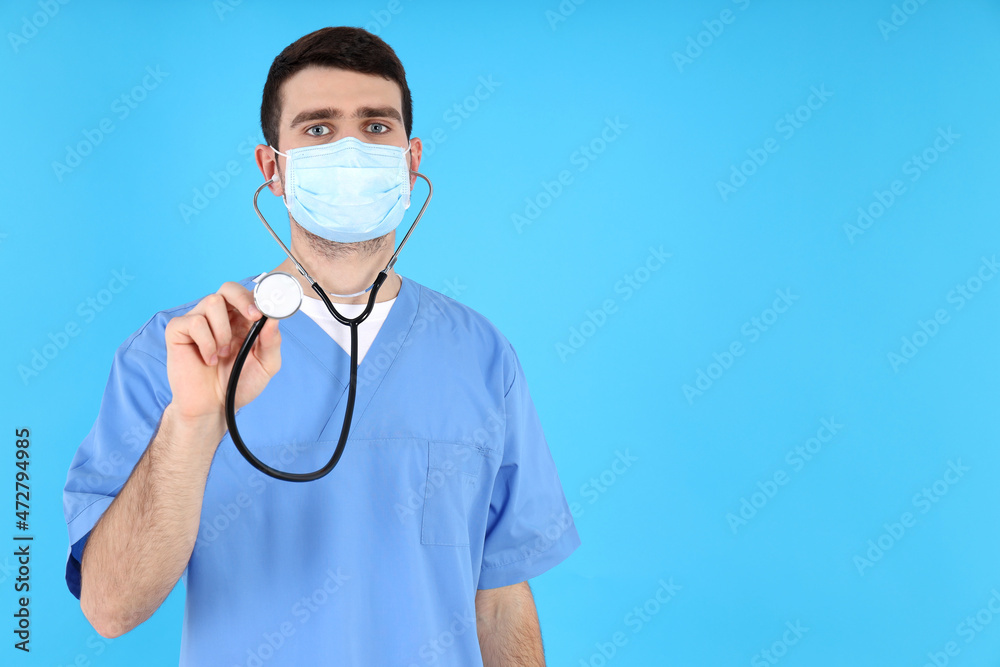 Male nurse in mask with stethoscope on blue background Male nurse in mask with stethoscope on blue background