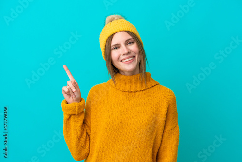 Young English woman wearing winter jacket isolated on blue background showing and lifting a finger in sign of the best © luismolinero