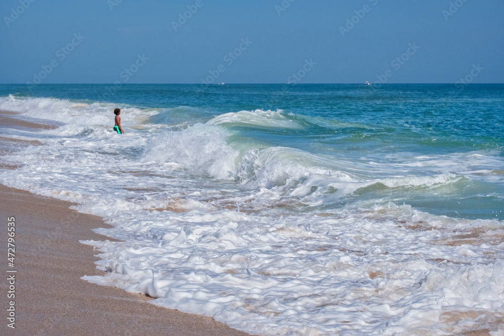 Boy wading in Atlantic Ocean, Florida