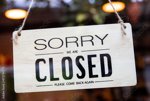 "Closed" tag on cafe or shop hang on door glass at entrance ready to service. white wooden open tag