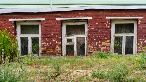 Windows with houseplants on the windowsills in the basement of the old house. The picture was taken in Russia, in the city of Orenburg