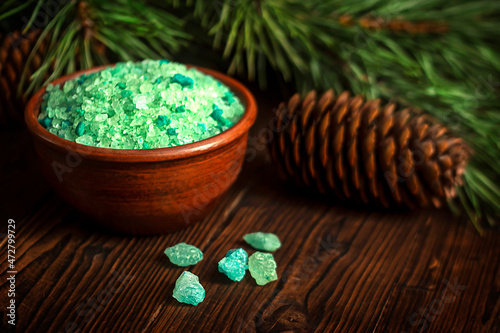 Spruce bath salt on a wooden background. Spruce branches in the background