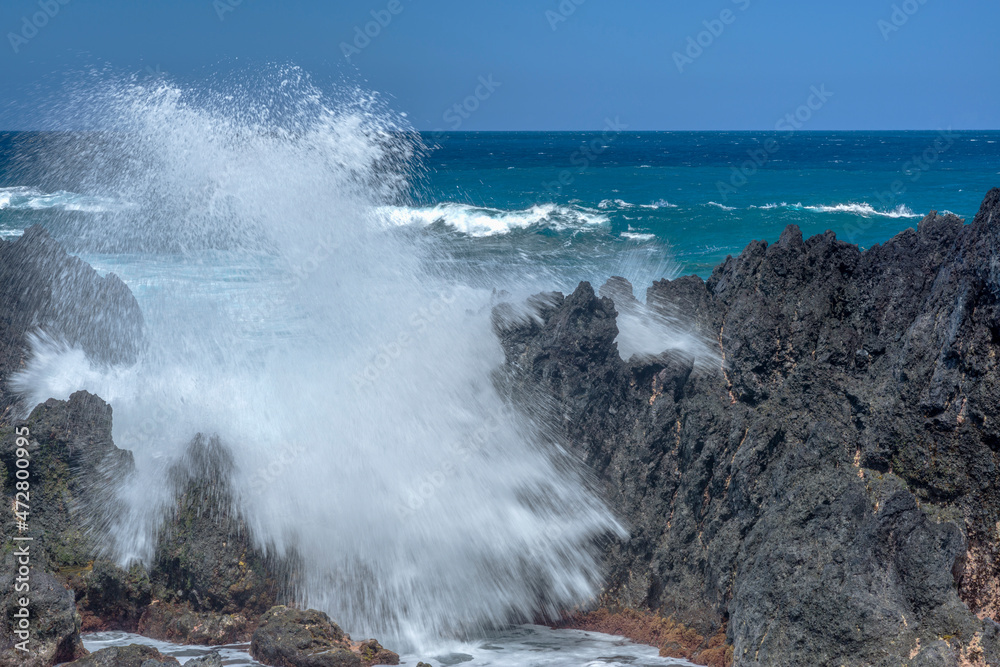 USA, Hawaii, Big Island of Hawaii. Laupahoehoe Point Beach Park, Incoming waves crash onto rough volcanic rock.